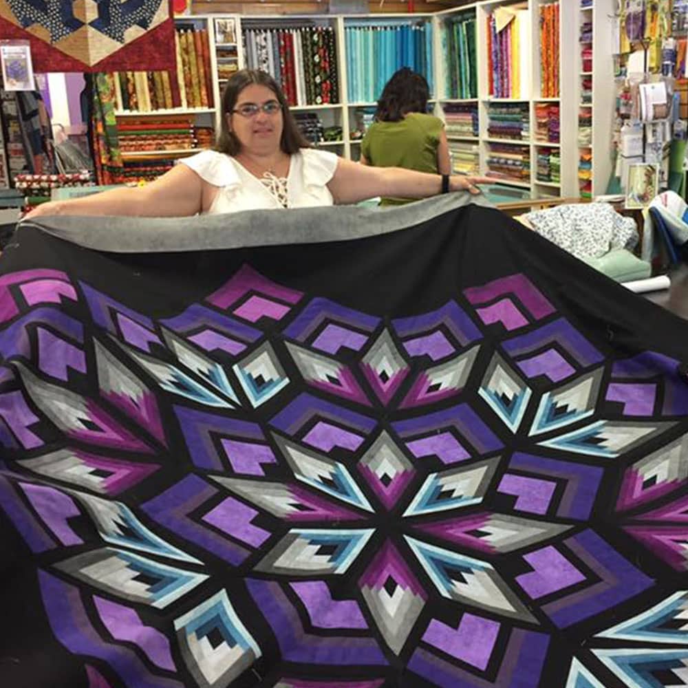 Jean with a custom quilt top at a local quilting store